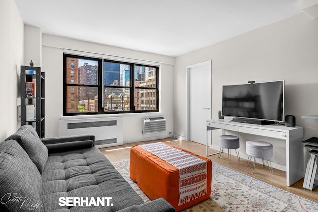 living room with radiator, wood finished floors, and a wall mounted AC