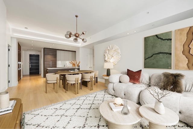 living area featuring light wood-style floors, a chandelier, recessed lighting, and baseboards