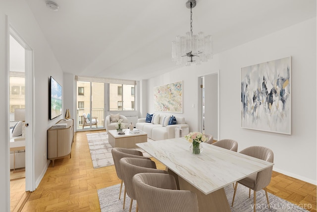 dining space featuring a chandelier and baseboards