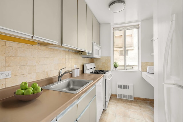 kitchen featuring white appliances, a sink, radiator heating unit, backsplash, and light tile patterned floors