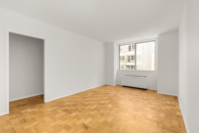 spare room featuring radiator heating unit and baseboards