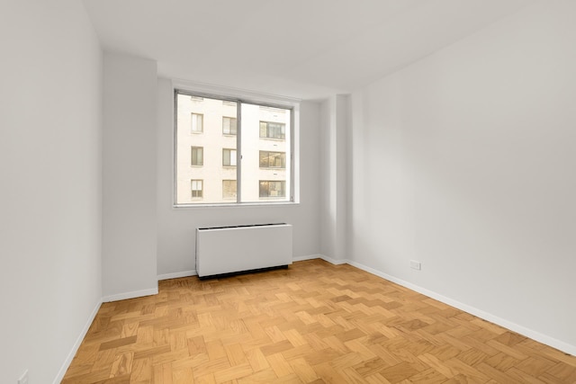 spare room featuring radiator heating unit and baseboards