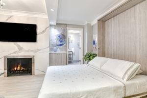220 E 73rd St Unit 1-A, New York City, NY 10021 - bedroom featuring ornamental molding, a fireplace, and beamed ceiling
