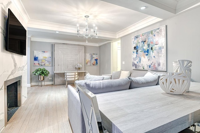 220 E 73rd St Unit 1-A, New York City, NY 10021 - dining space featuring a tray ceiling, a chandelier, light wood finished floors, crown molding, and a high end fireplace