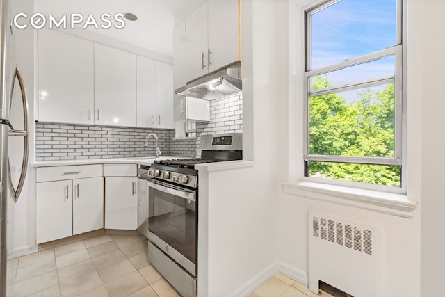 640 W 231st St Unit 5Ff, New York City, NY 10463 - kitchen featuring stainless steel gas stove, radiator heating unit, under cabinet range hood, and white cabinetry