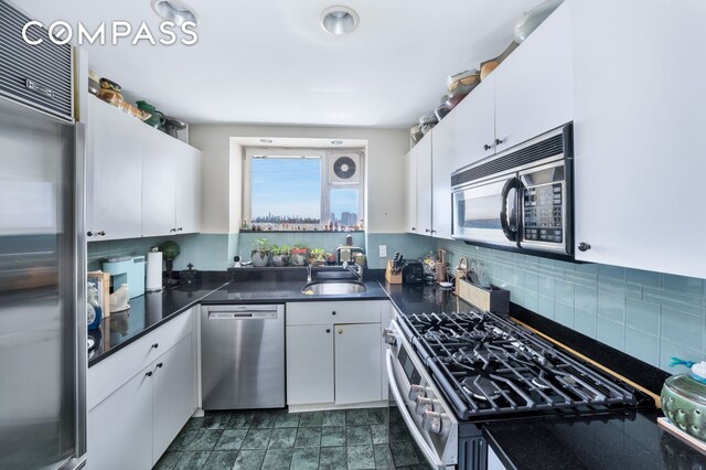 25 Sutton Pl S Unit 8G, New York City, NY 10022 - kitchen with stainless steel appliances, dark countertops, white cabinetry, and a sink