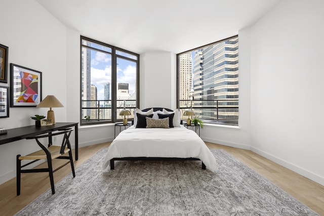 75 Wall St Unit Phl3, New York City, NY 10005 - bedroom featuring wood finished floors, a view of city, and baseboards