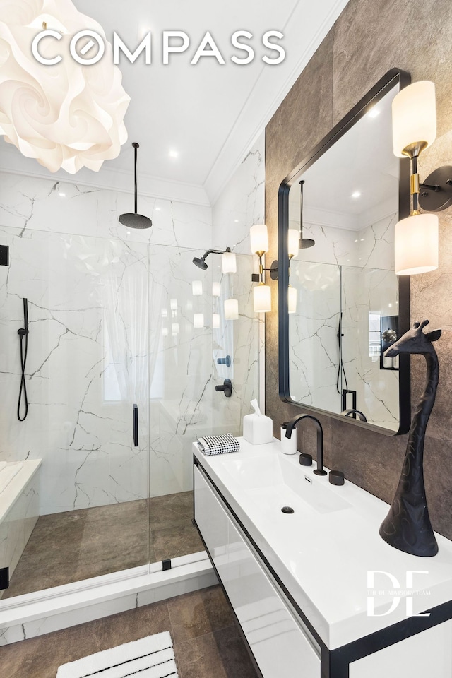 full bath featuring ornamental molding, a marble finish shower, and vanity
