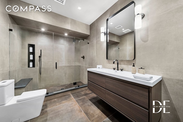 full bathroom featuring toilet, a shower stall, vanity, and tile walls