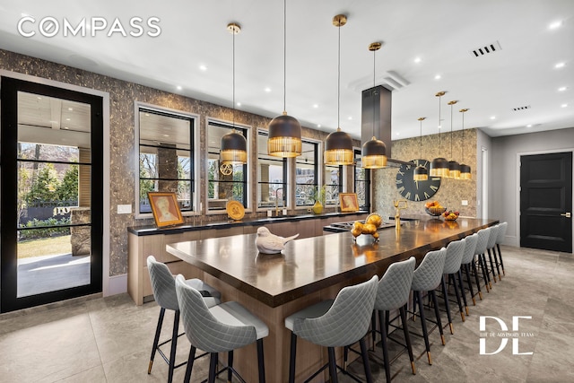 52 Nicolosi Loop, New York City, NY 10312 - kitchen featuring dark countertops, recessed lighting, a large island with sink, pendant lighting, and a breakfast bar area