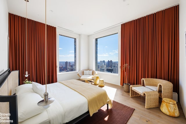 bedroom with wood finished floors and a city view
