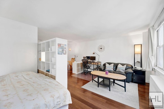 bedroom featuring a desk, dark wood-style flooring, and radiator