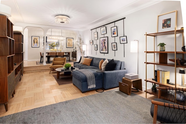 sitting room with arched walkways, crown molding, baseboards, and a chandelier