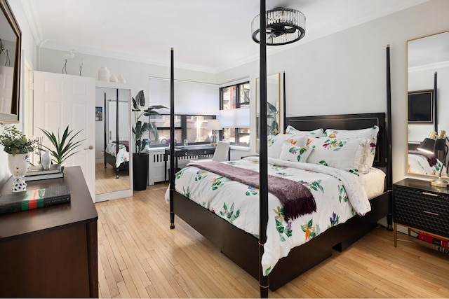 bedroom with ornamental molding and hardwood / wood-style floors