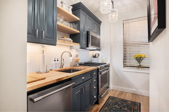 kitchen with stainless steel appliances, a sink, decorative backsplash, butcher block countertops, and open shelves