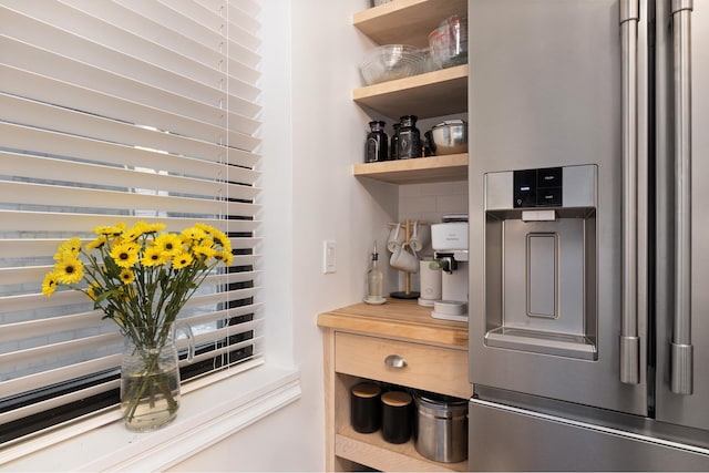 kitchen view of stainless steel fridge and open shelves