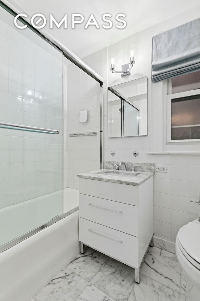full bathroom with marble finish flooring, toilet, enclosed tub / shower combo, and vanity