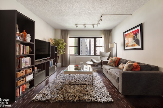 living area with a textured ceiling, rail lighting, and hardwood / wood-style flooring