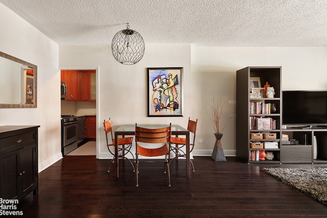 dining area featuring dark wood finished floors, a textured ceiling, a chandelier, and baseboards