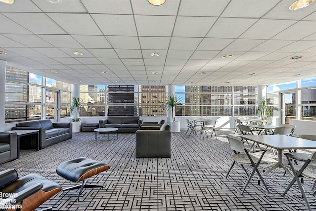 common area with a paneled ceiling, recessed lighting, and expansive windows