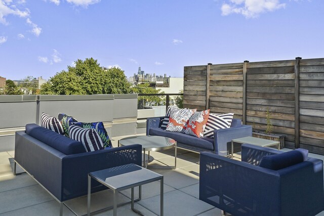 view of patio featuring an outdoor hangout area, a view of city, and fence