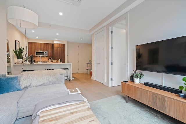 living area featuring light wood-type flooring and recessed lighting