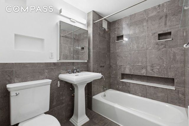 full bathroom featuring tile walls, toilet, and bathtub / shower combination