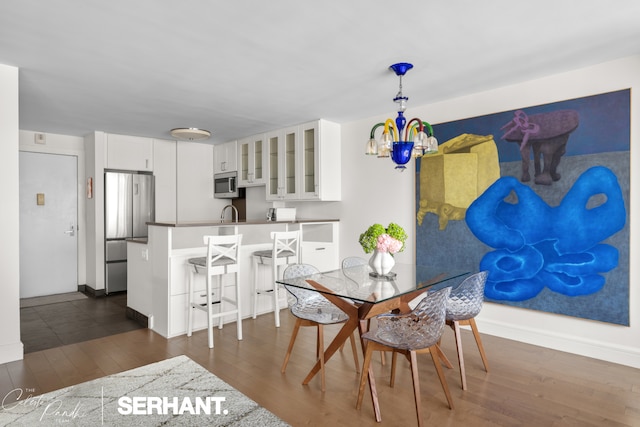 270 W 17th St Unit 12Bc, New York City, NY 10011 - dining space featuring a chandelier, dark wood-style floors, and baseboards