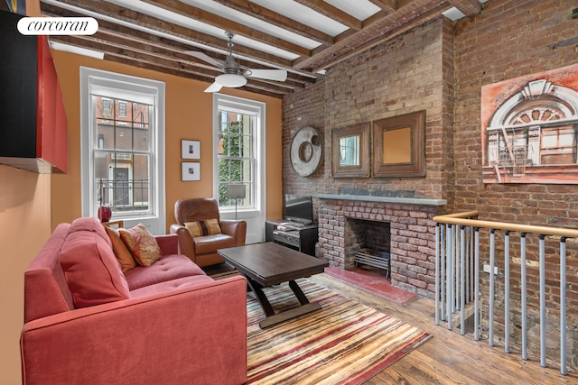 352 W 12th Street Maisonette, New York City, NY 10014 - living area featuring wood finished floors, beamed ceiling, ceiling fan, brick wall, and a brick fireplace