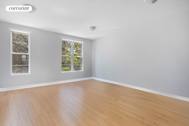 spare room with light wood-style flooring and baseboards