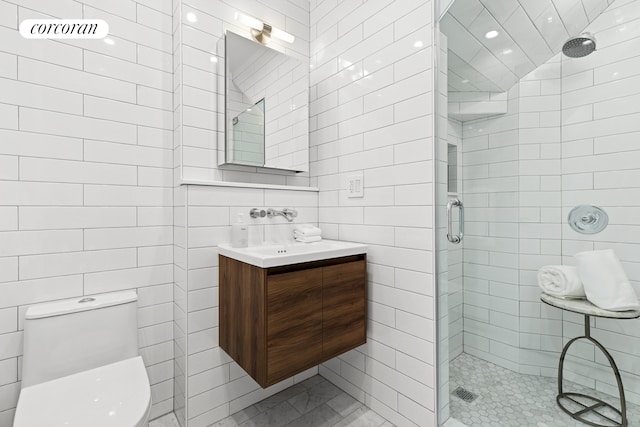 full bathroom with tile walls, a stall shower, toilet, vanity, and recessed lighting