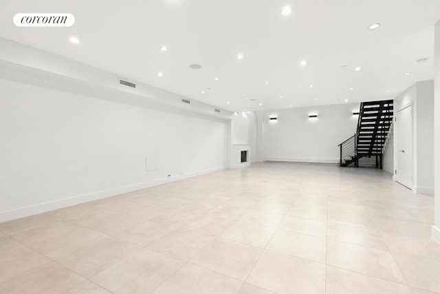 below grade area featuring stairs, recessed lighting, light tile patterned floors, and baseboards