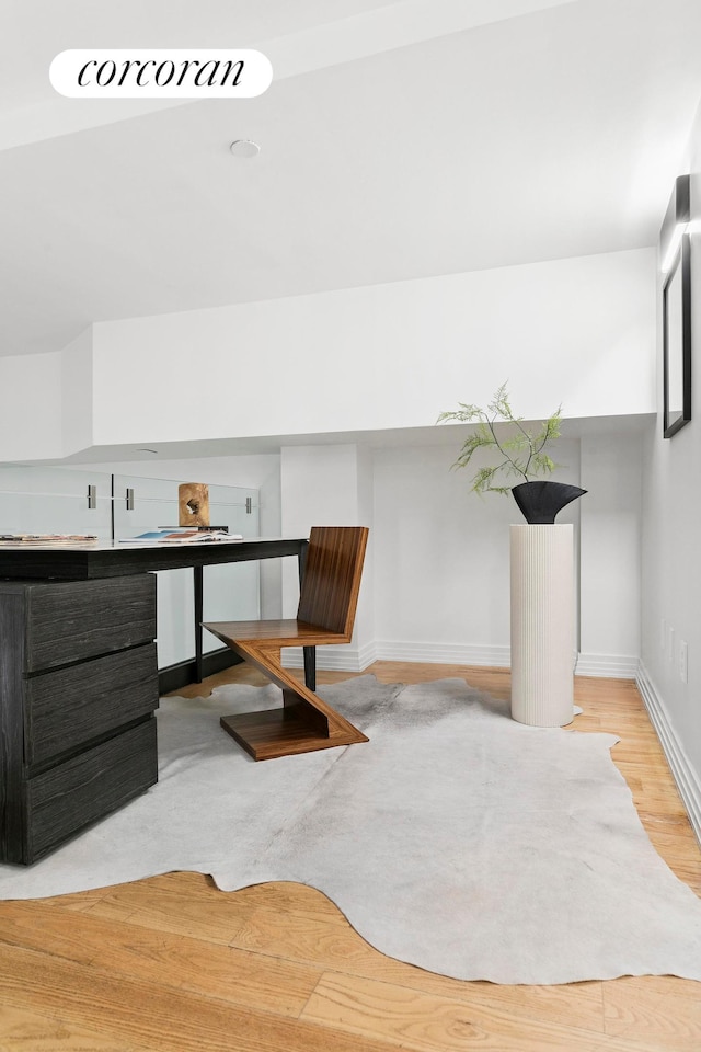 unfurnished office featuring baseboards and wood finished floors