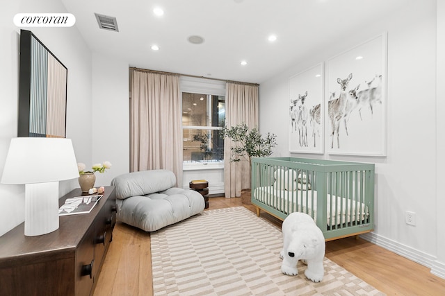 bedroom with wood finished floors, recessed lighting, and baseboards