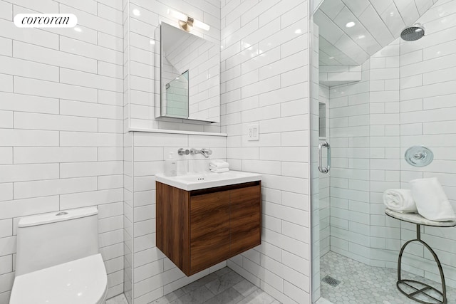 full bath featuring tile walls, a shower stall, toilet, vanity, and recessed lighting