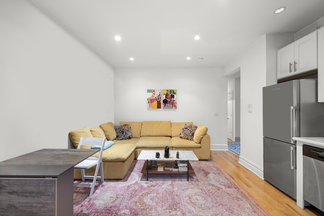 living area with light wood-type flooring, recessed lighting, and baseboards