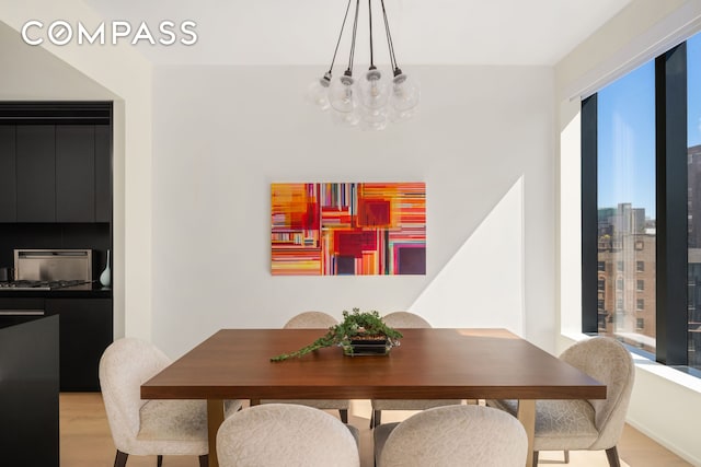 dining area with light wood finished floors and a chandelier