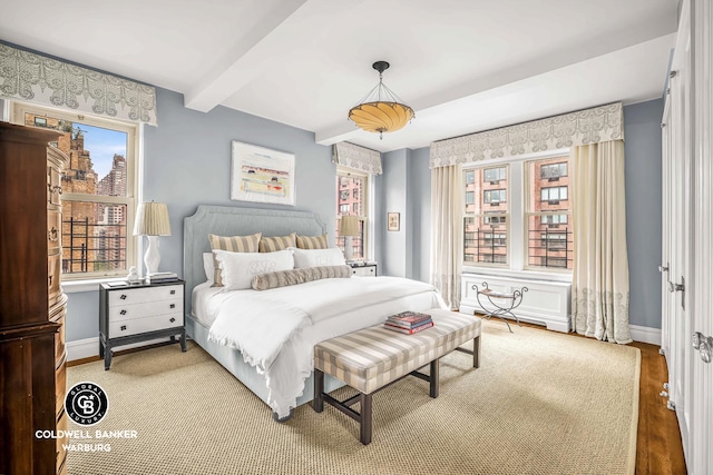 215 E 72nd St Unit 12E, New York City, NY 10021 - bedroom featuring baseboards, wood finished floors, and beam ceiling