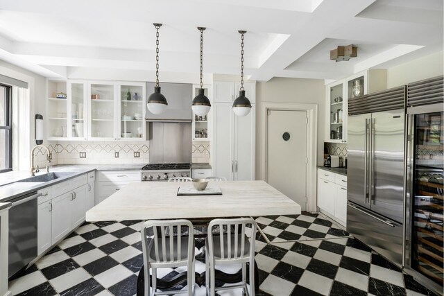 257 W 86th St Unit 3/4A, New York City, NY 10024 - kitchen with stainless steel appliances, dark flooring, a sink, white cabinetry, and coffered ceiling