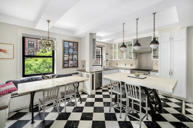 dining space with a tray ceiling, tile patterned floors, and plenty of natural light