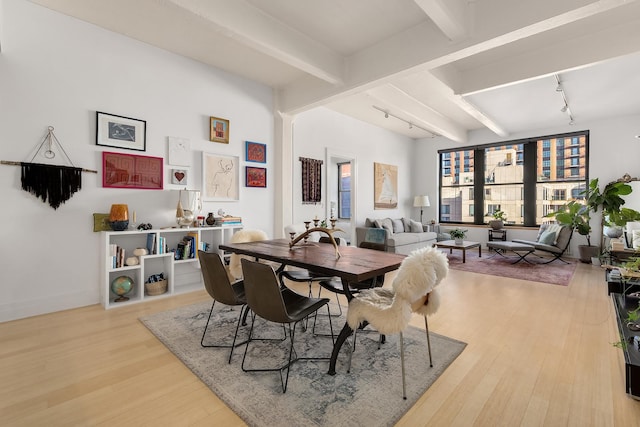 70 Washington St Unit 9A, New York City, NY 11201 - dining space featuring rail lighting, beamed ceiling, wood finished floors, and baseboards