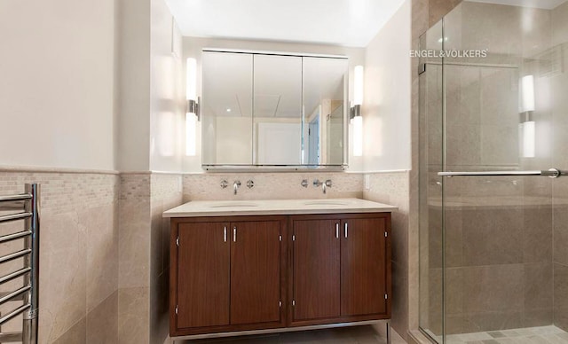 200 E 66th St Unit C1605, New York City, NY 10065 - bathroom with tile walls, a shower stall, double vanity, wainscoting, and radiator heating unit