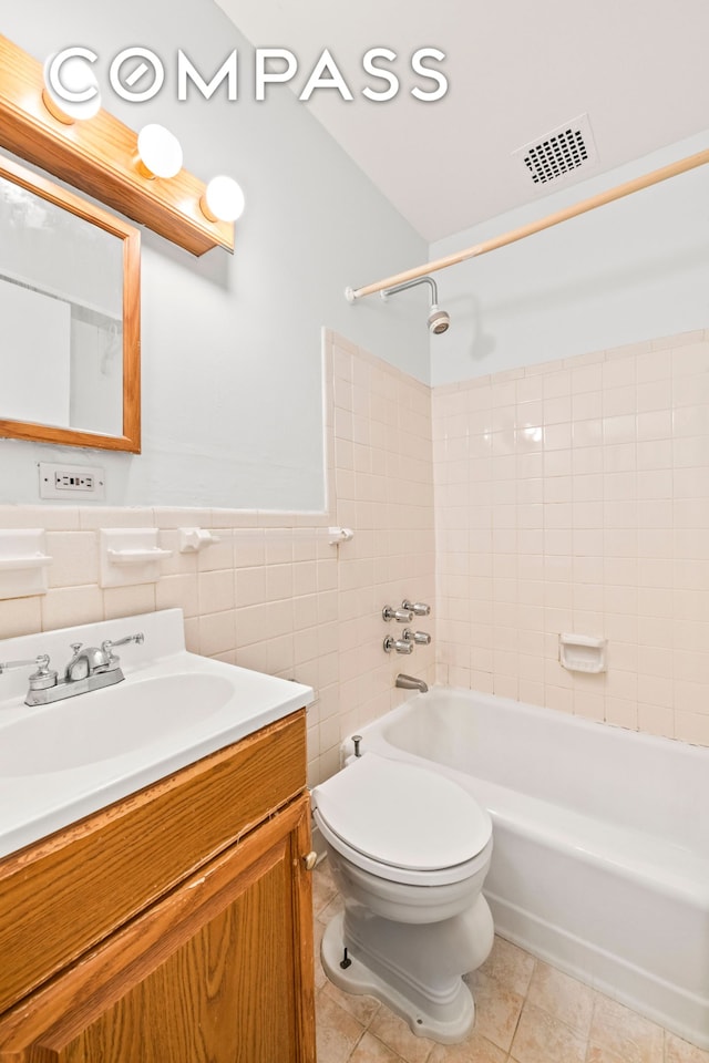 132 W 71st St Unit 3, New York City, NY 10023 - bathroom featuring vanity, tub / shower combination, toilet, tile walls, and tile patterned flooring