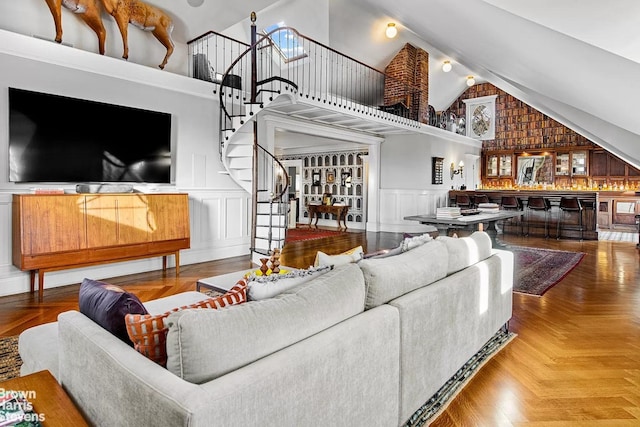 1305 Albemarle Rd, New York City, NY 11226 - living room with high vaulted ceiling, a decorative wall, stairs, and a wainscoted wall