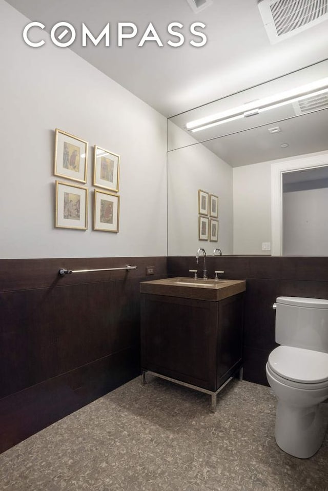 182 W 82nd St Unit 4E, New York City, NY 10024 - bathroom featuring vanity, toilet, and a wainscoted wall