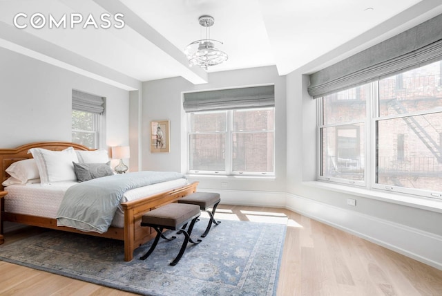 182 W 82nd St Unit 4E, New York City, NY 10024 - bedroom featuring wood finished floors, a chandelier, and baseboards