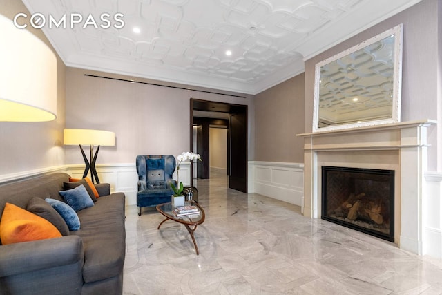 182 W 82nd St Unit 4E, New York City, NY 10024 - living room featuring marble tiled flooring, a decorative wall, crown molding, a glass covered fireplace, and wainscoting
