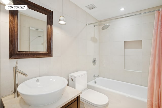 bathroom featuring tile walls, shower / bath combo, toilet, vanity, and recessed lighting