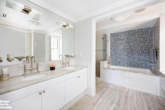 full bath with tiled shower, ornamental molding, double vanity, and wood finished floors