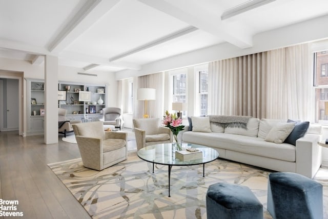 living room featuring beam ceiling and light wood-style flooring